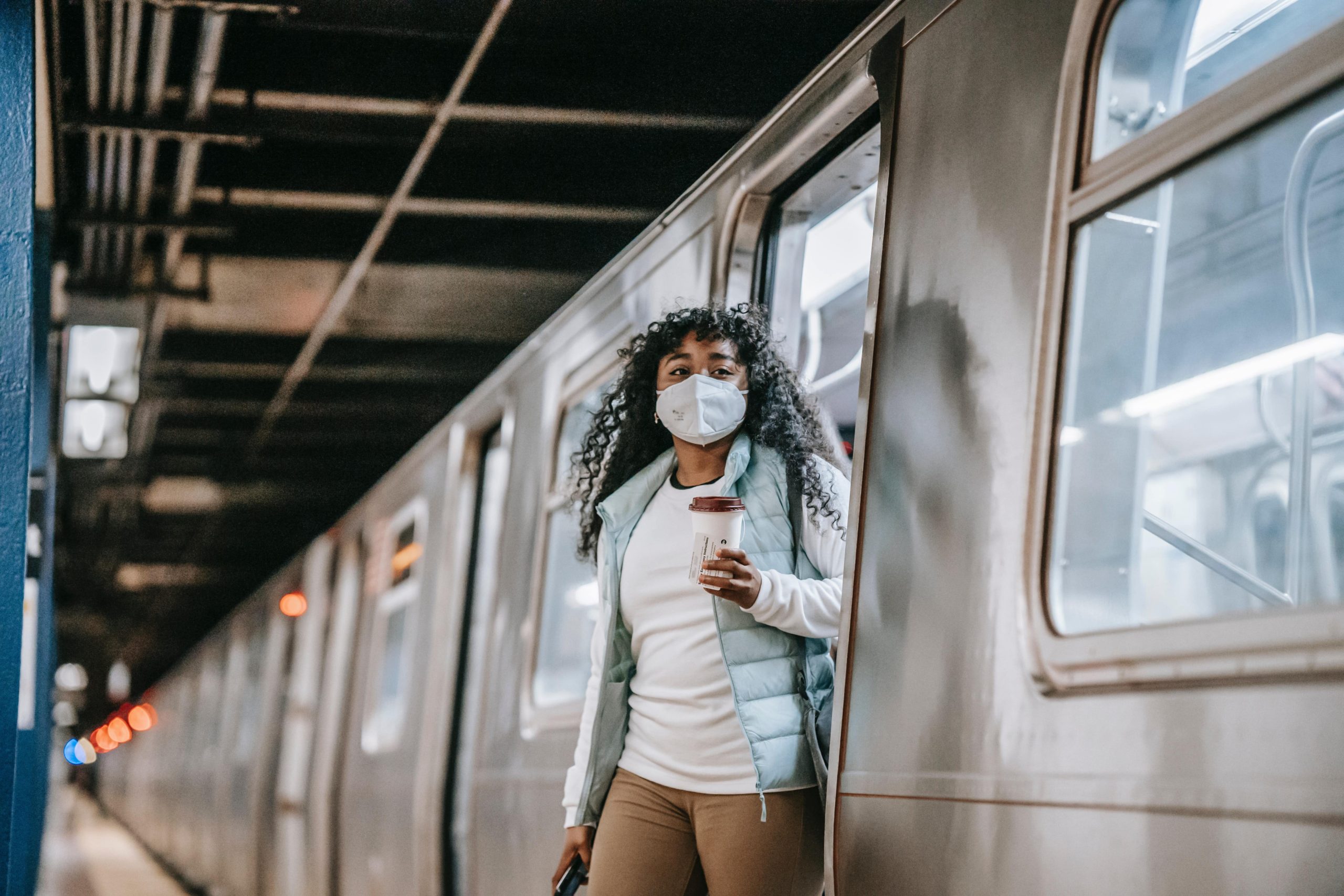 Lady walking out of train with face mask